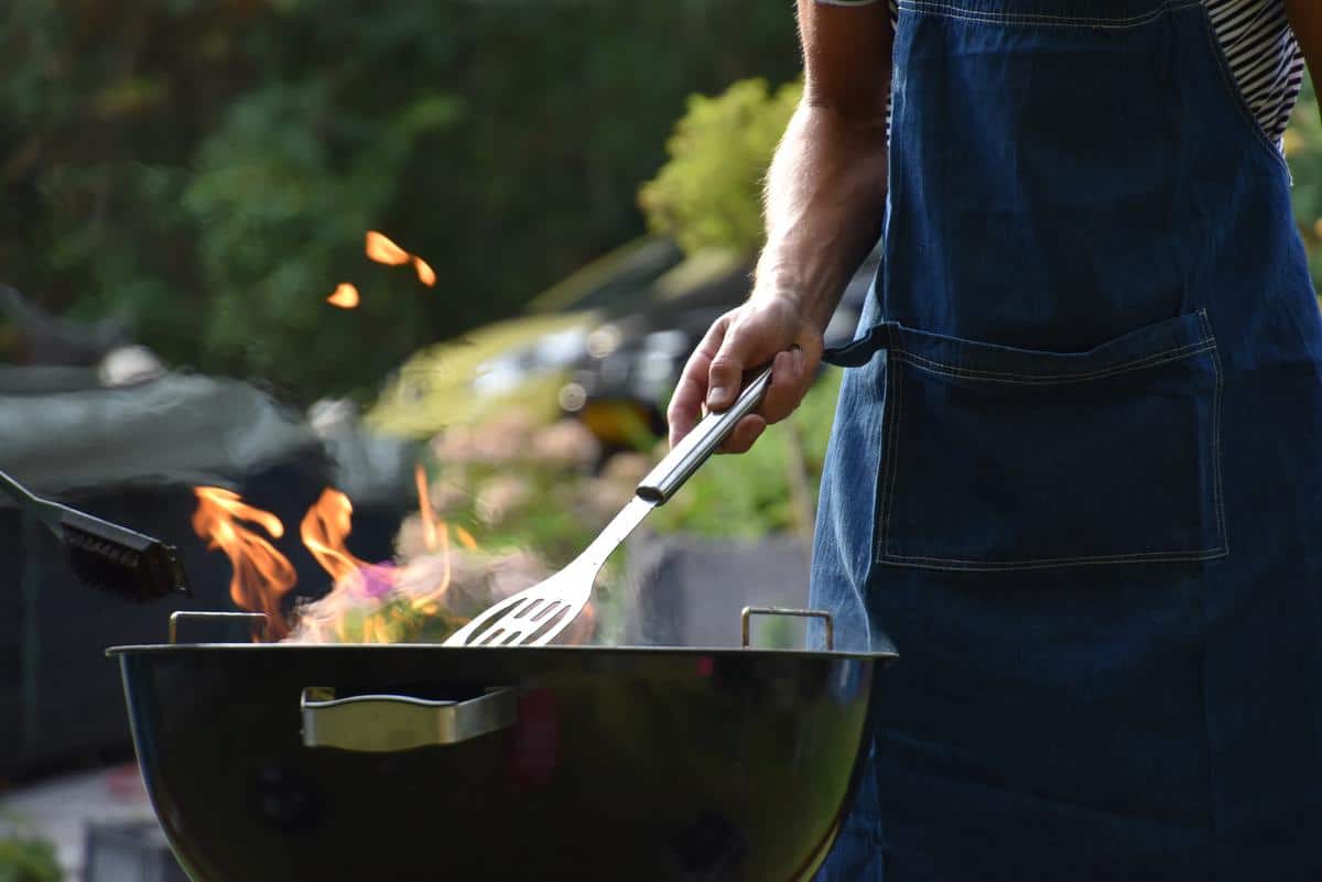 An image of a person grilling food on an open flame.