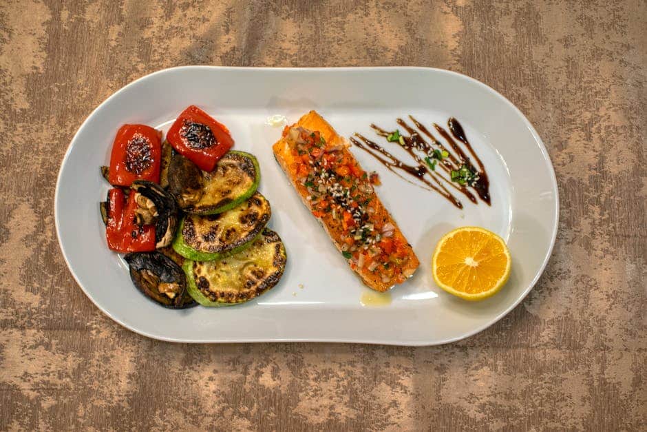 A succulent grilled fish on a bed of colorful vegetables, representing the deliciousness of grilling fish